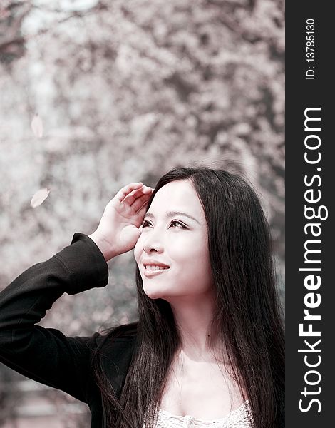 Young Asian woman with long hair sitting and enjoying the scenery in spring. This is the cherry blossom season. Young Asian woman with long hair sitting and enjoying the scenery in spring. This is the cherry blossom season.