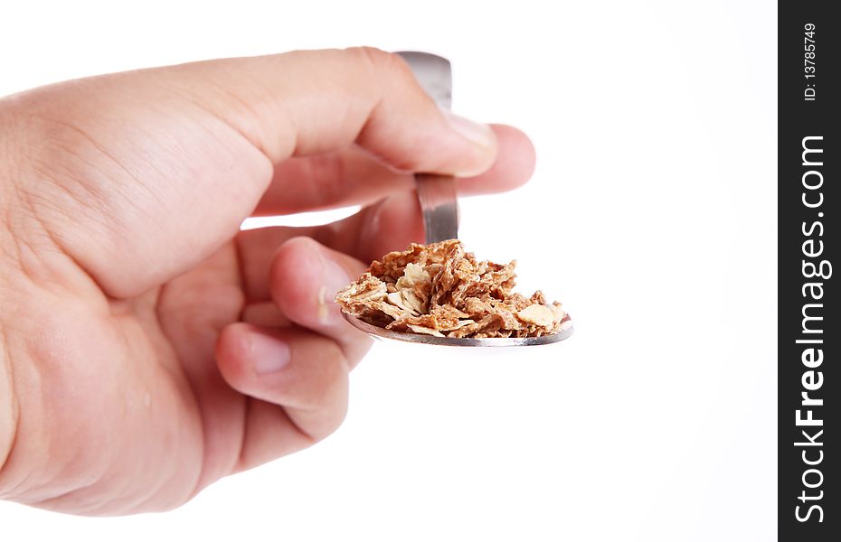 Hand with Cereal on a spoon over white background. Front view