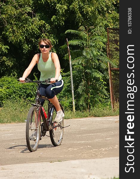 Woman cycling in a park sunny day