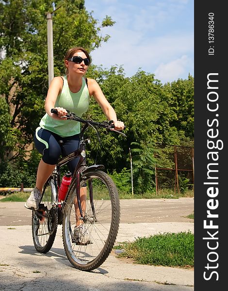 Woman cycling in a park sunny day