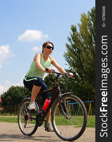 Woman cycling in a park sunny day
