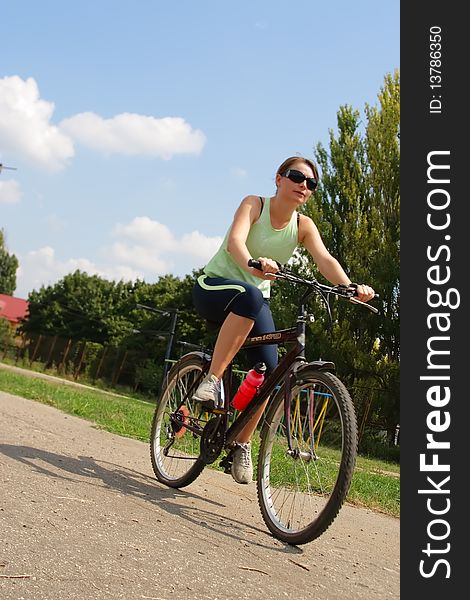 Woman cycling in a park sunny day