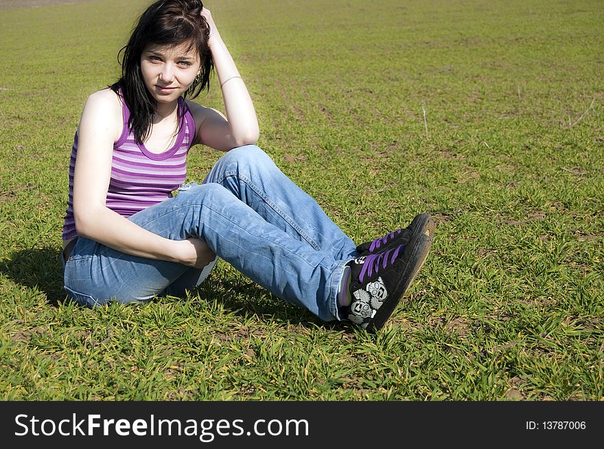 Beautiful Brunette Girl on green grass field