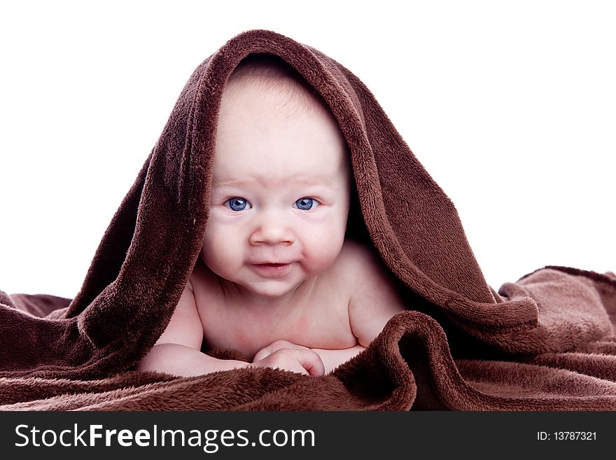 A beautiful baby under a brown towel on white