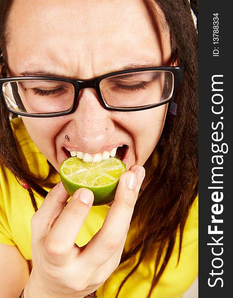 Girl with dreadlocks eating fresh lime. Girl with dreadlocks eating fresh lime