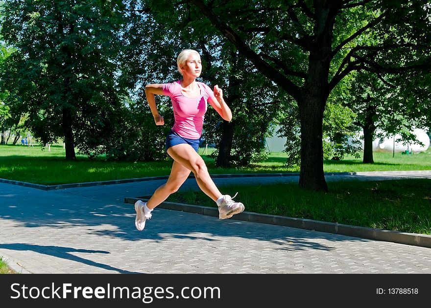 Young blonde woman running in park. Young blonde woman running in park