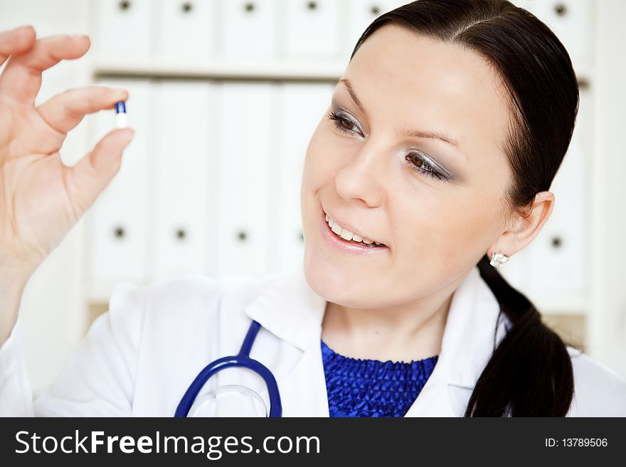 Closeup of doctor woman holding pill