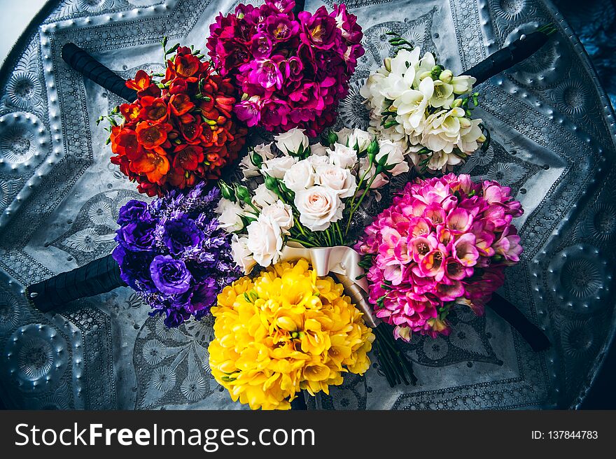 Colourful wedding bouquet arrangement lying on a vintage patterned metal tin Indian tray. Colourful wedding bouquet arrangement lying on a vintage patterned metal tin Indian tray