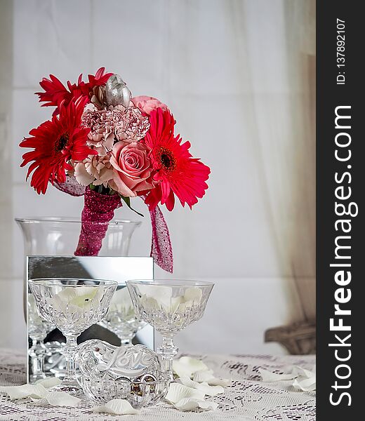 A Bunch Of Red And Pink Flowers With A Silver Heart