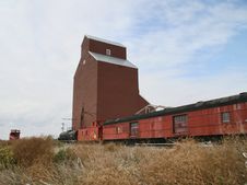 Old Train By Grain Elevator Royalty Free Stock Image