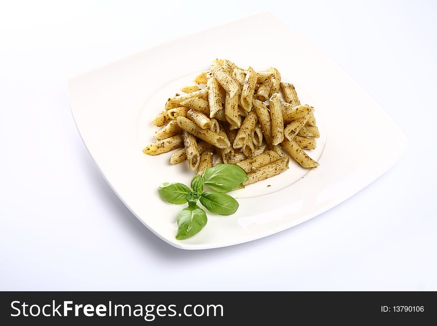 Penne with pesto decorated with basil on a plate