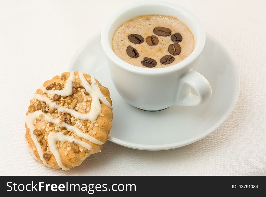 Cup of cappuccino with coffee grains and cookies on a white linen cloth. Cup of cappuccino with coffee grains and cookies on a white linen cloth