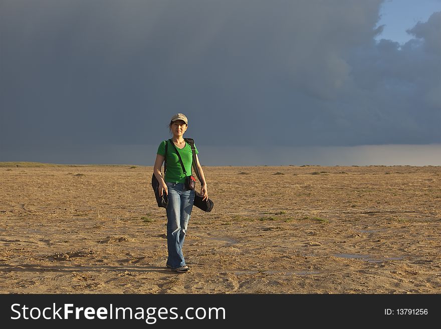 A young asian lady in the upcoming rainstorm desert. A young asian lady in the upcoming rainstorm desert