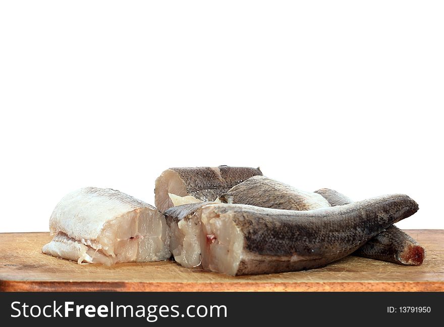 Sliced raw fish lying on wooden cutting board. Isolated on white background with clipping path. Sliced raw fish lying on wooden cutting board. Isolated on white background with clipping path