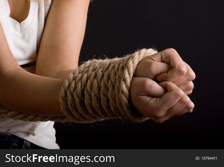 Related thick rope hands clenched into fists on a dark background. Related thick rope hands clenched into fists on a dark background