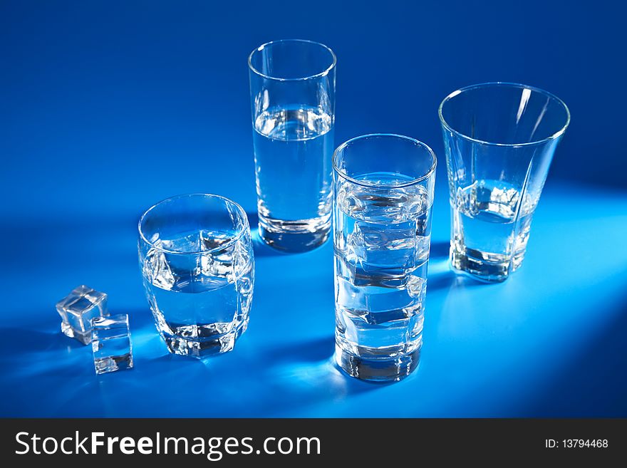 Glasses of water over blue