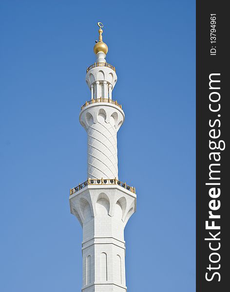 The intricately designed marble clad minaret with gold cresent and balustrade designs