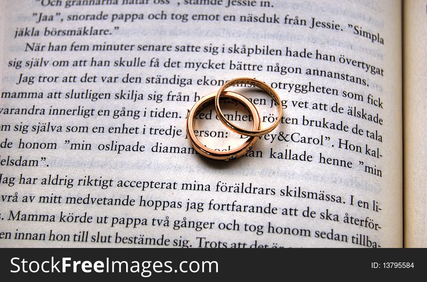 Two golden wedding ring sin a bookÂ´s centrefold. Two golden wedding ring sin a bookÂ´s centrefold.