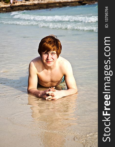 Happy boy in foam of beach