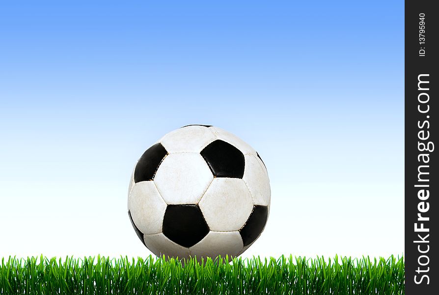 Soccer ball on the green field with grass