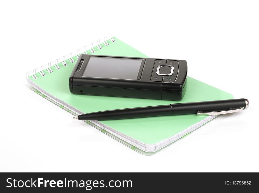 Black mobile phone on a white background with a pad and pen