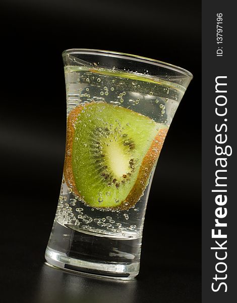 Cocktail glass with kiwi on black background