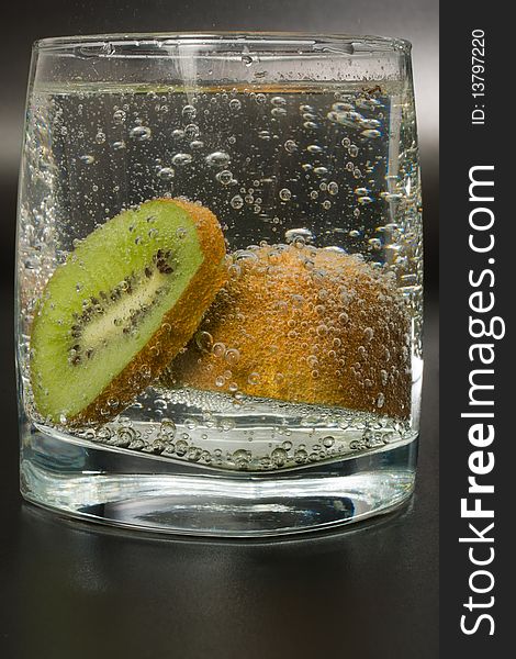 Cocktail glass with kiwi on black background