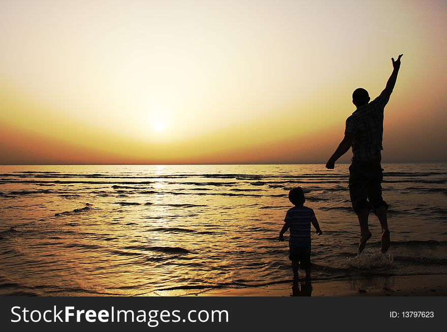 Father and son at sunset on the sea