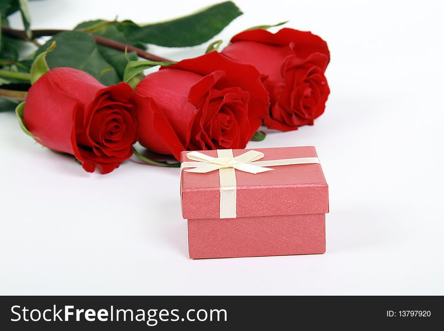 Red roses and gift on white
