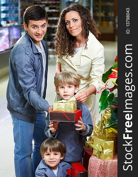 Happy family in shop with boxes of gifts. Happy family in shop with boxes of gifts