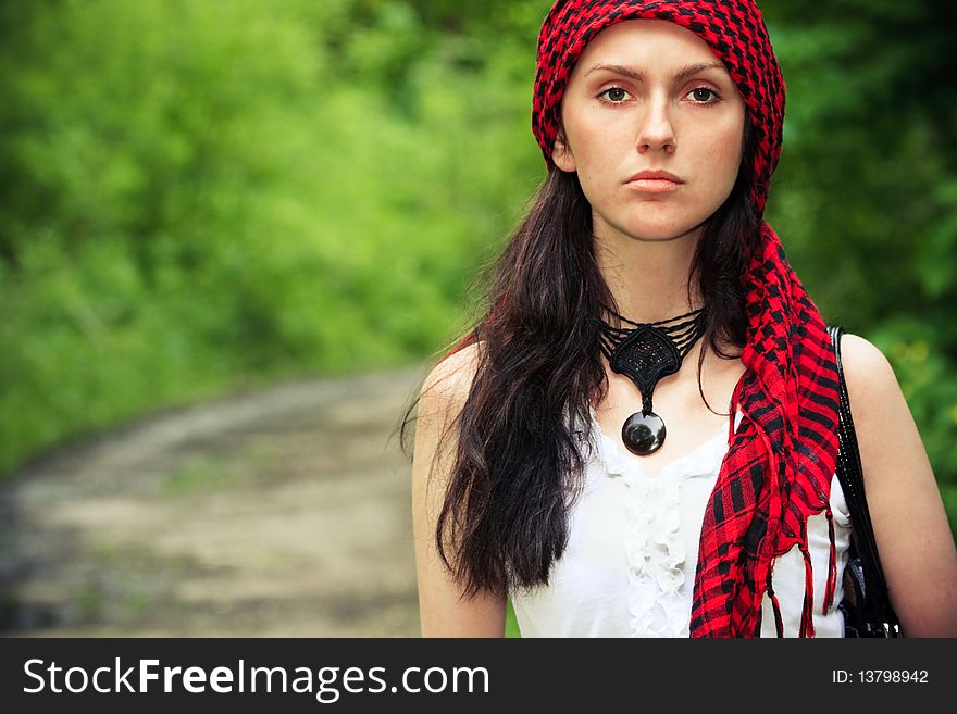 Girl sitting in the forest, on his head wearing a red kerchief. Girl sitting in the forest, on his head wearing a red kerchief