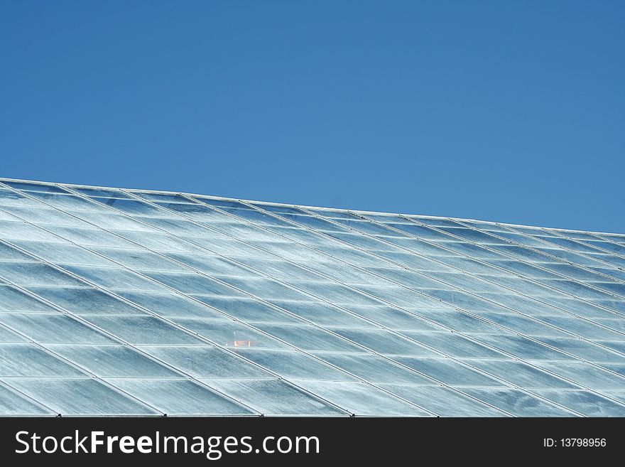 A green house roof with blue sky. A green house roof with blue sky
