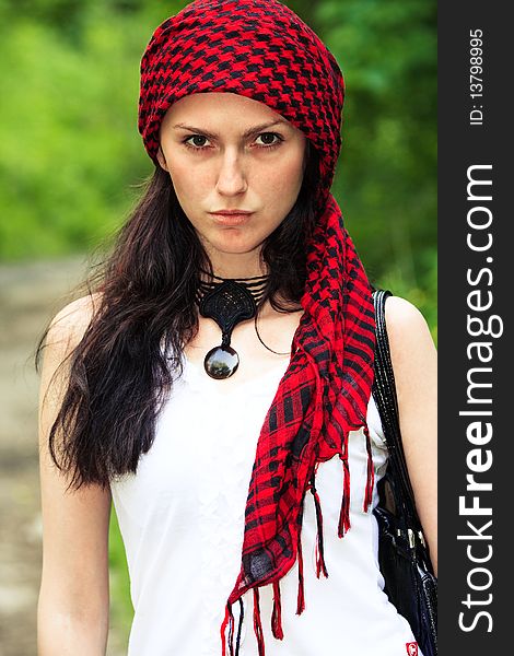 Girl sitting in the forest, on his head wearing a red kerchief. Girl sitting in the forest, on his head wearing a red kerchief