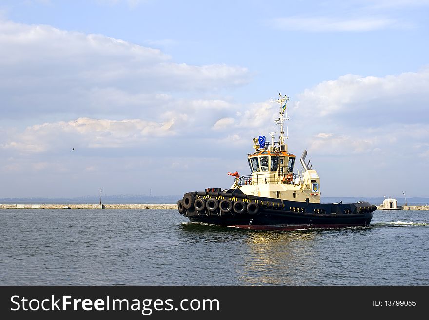 Modern powerful tugboat in the waters of the commercial port. Modern powerful tugboat in the waters of the commercial port