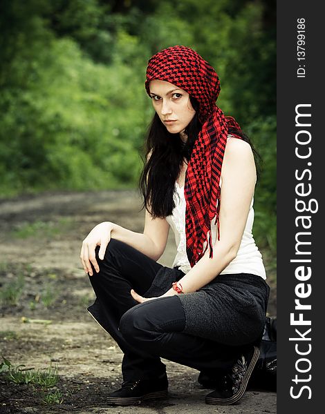 Girl sitting in the forest, on his head wearing a red kerchief. Girl sitting in the forest, on his head wearing a red kerchief