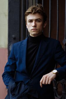 Portrait Of An Attractive Man In A Suit And A Black Sweater, Close-up, On His Hand A Gold Watch, Brooding Pose, Looking Royalty Free Stock Photography