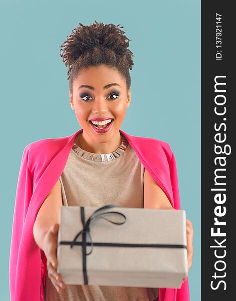 Beautiful attractive cheerful smiling young woman mixed rase holding saint valentine`s day present in her hands