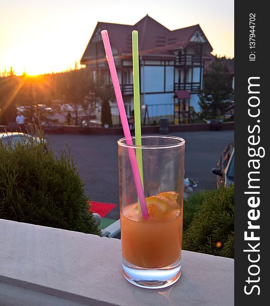 A cocktail with lemon served at sunset on the porch. A cocktail with lemon served at sunset on the porch