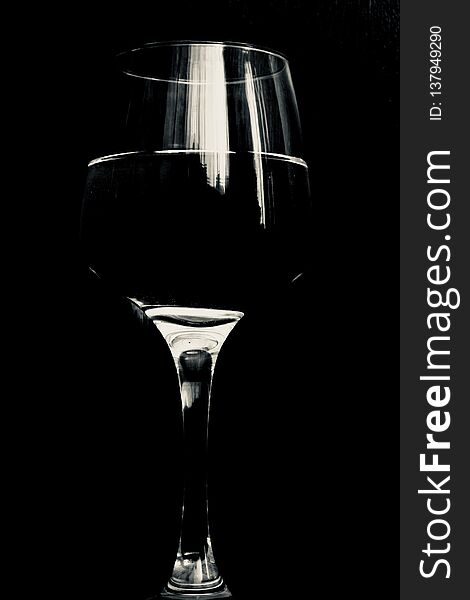 Wine glass half full of water on black background. Wine glass half full of water on black background