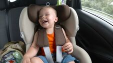 Baby Boy In The Children`s Car Seat In The Car. Kid Smiles, Laughs And Waves His Hands Happily. Stock Photos