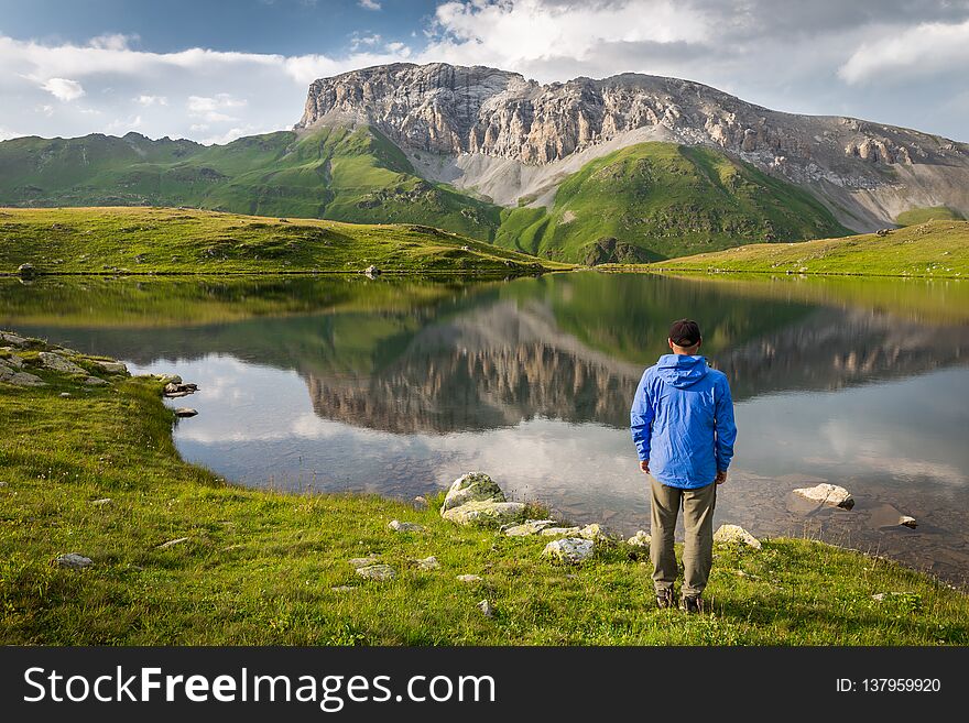 Traveler around the mountain lake and rocky peak. Adventure, travel, tourism and hike concept. Traveler around the mountain lake and rocky peak. Adventure, travel, tourism and hike concept