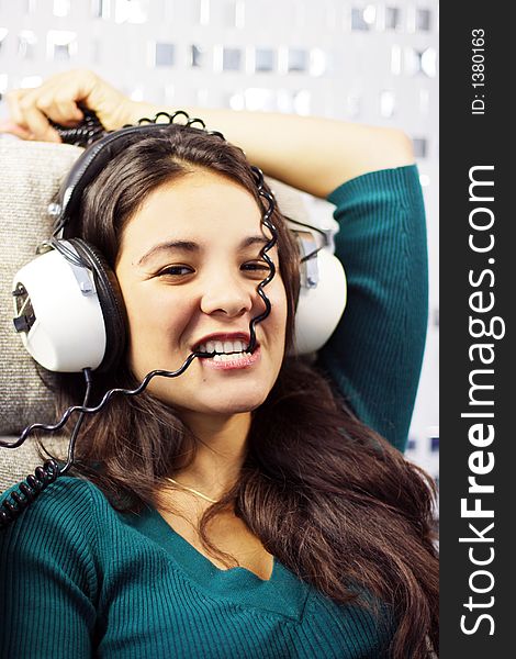 Beautiful young woman listening to music and biting headphone coil. Beautiful young woman listening to music and biting headphone coil