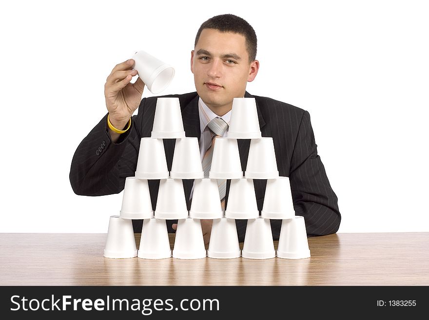 Businessman building cups' pyramid