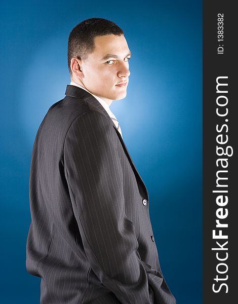 Young businessman standing (blue background)