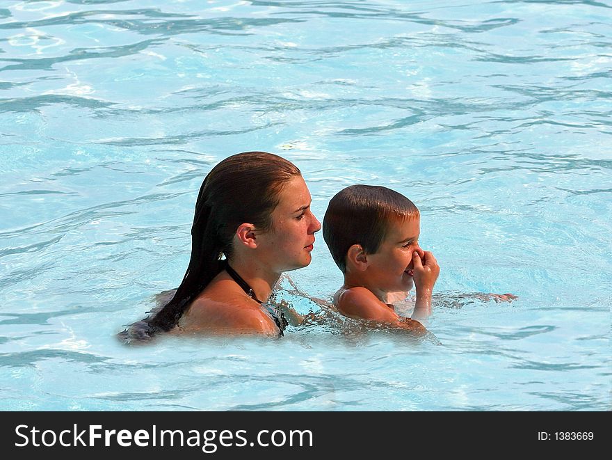 Older sibling helping younger to swim. Older sibling helping younger to swim