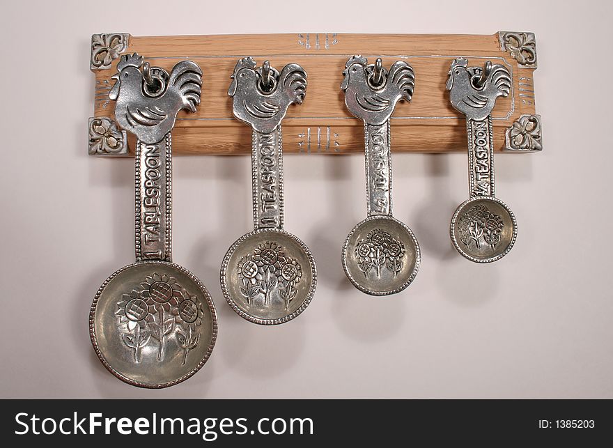 Set of unique silver measuring spoons with sunflower pattern and rooster on the handle. Set of unique silver measuring spoons with sunflower pattern and rooster on the handle