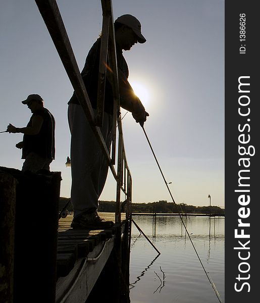 Two men fishing in silhouette. Two men fishing in silhouette.