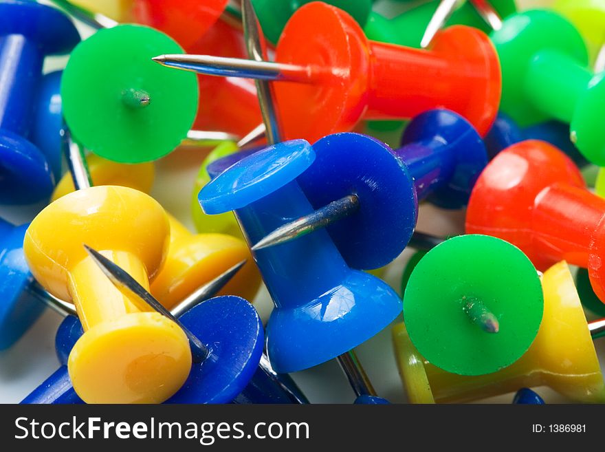 Colored pins from above on a white background