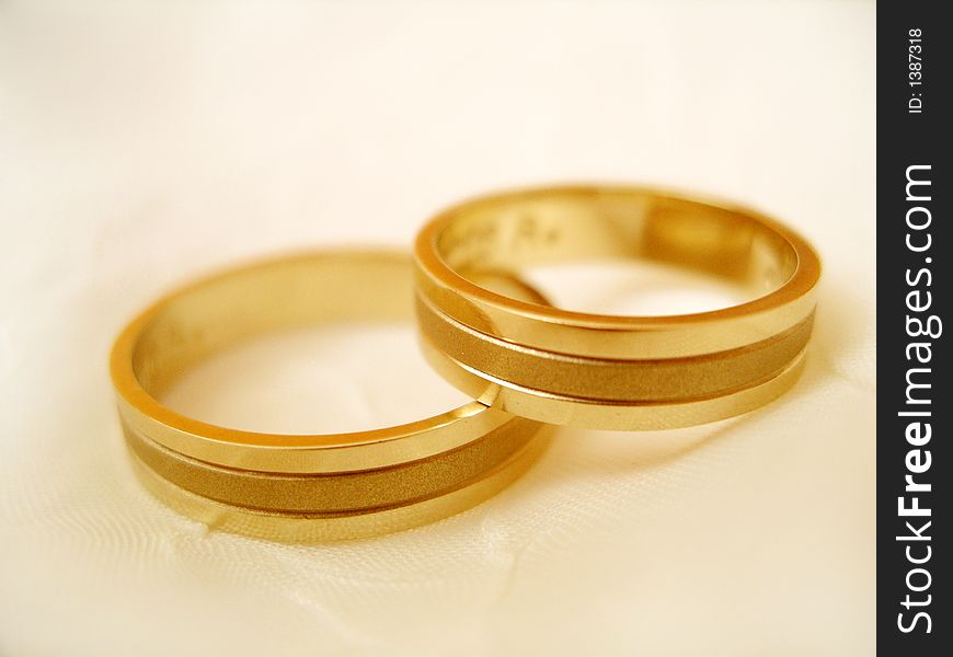 Two wedding rings on the off-white background