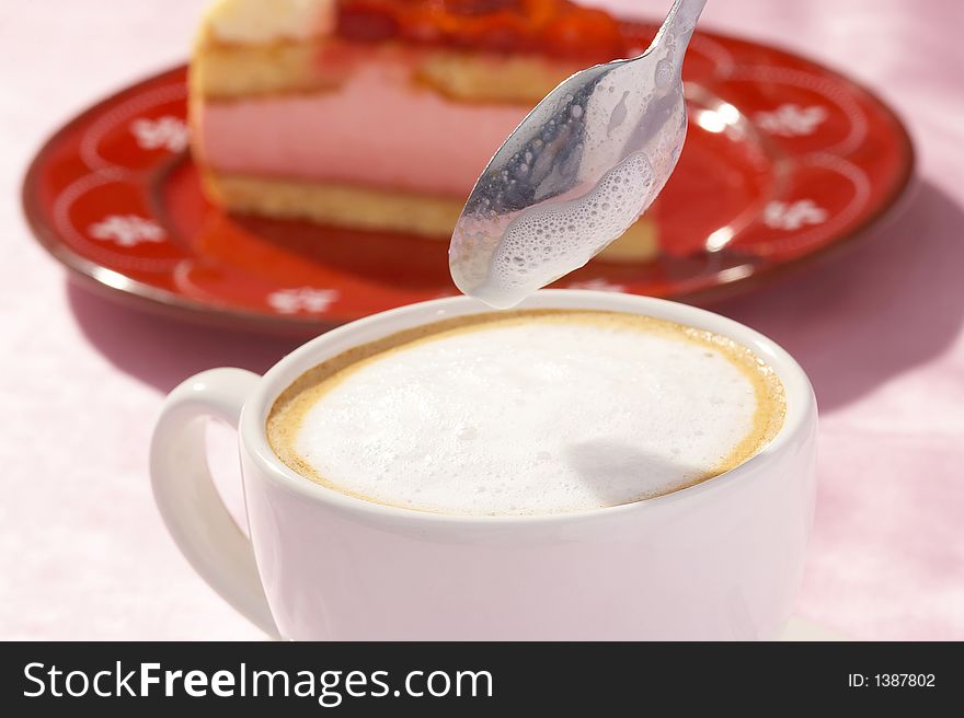 A cup of coffee and one  piece of strawberry cake. A cup of coffee and one  piece of strawberry cake